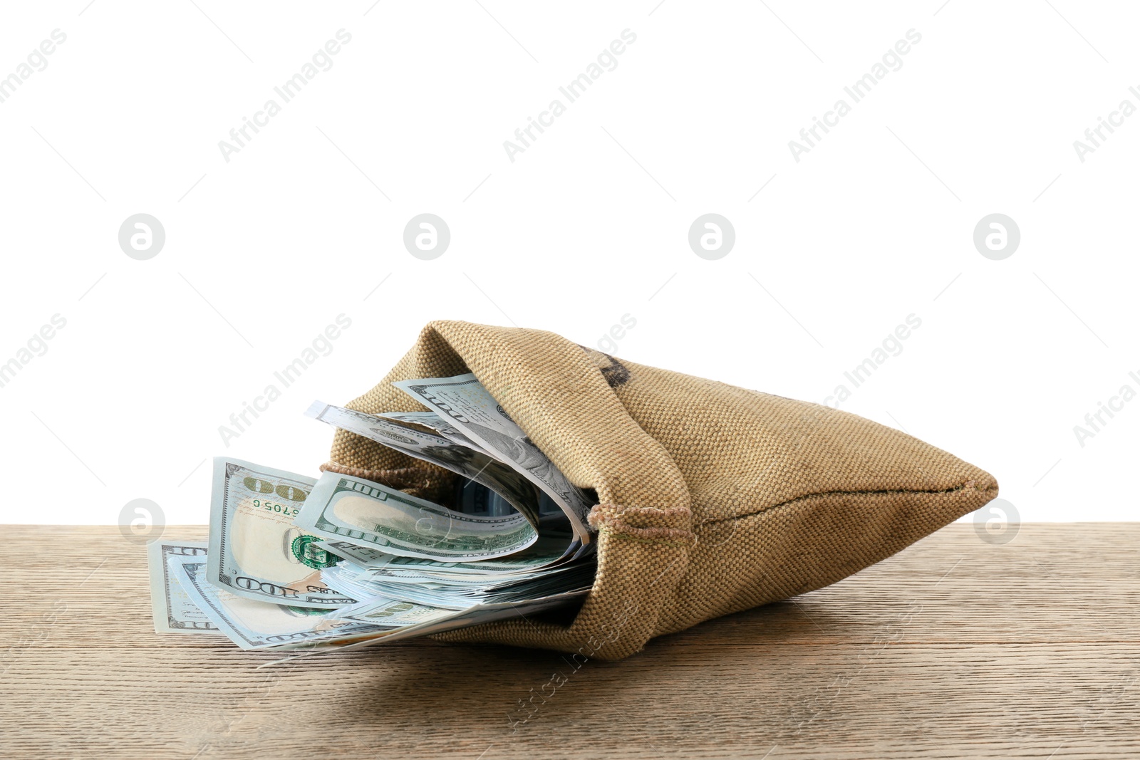 Photo of Dollar banknotes in bag on wooden table against white background