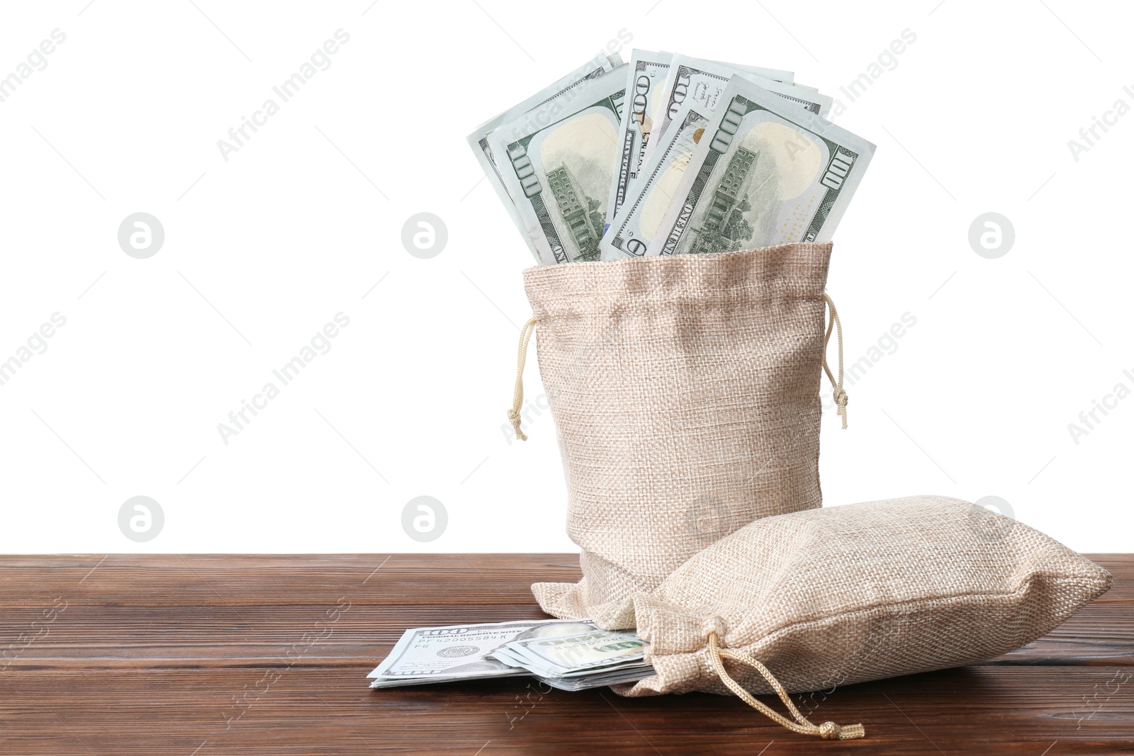 Photo of Dollar banknotes in bags on wooden table against white background, space for text