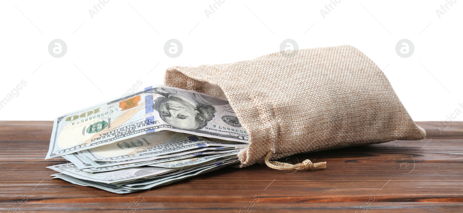 Photo of Dollar banknotes in bag on wooden table against white background