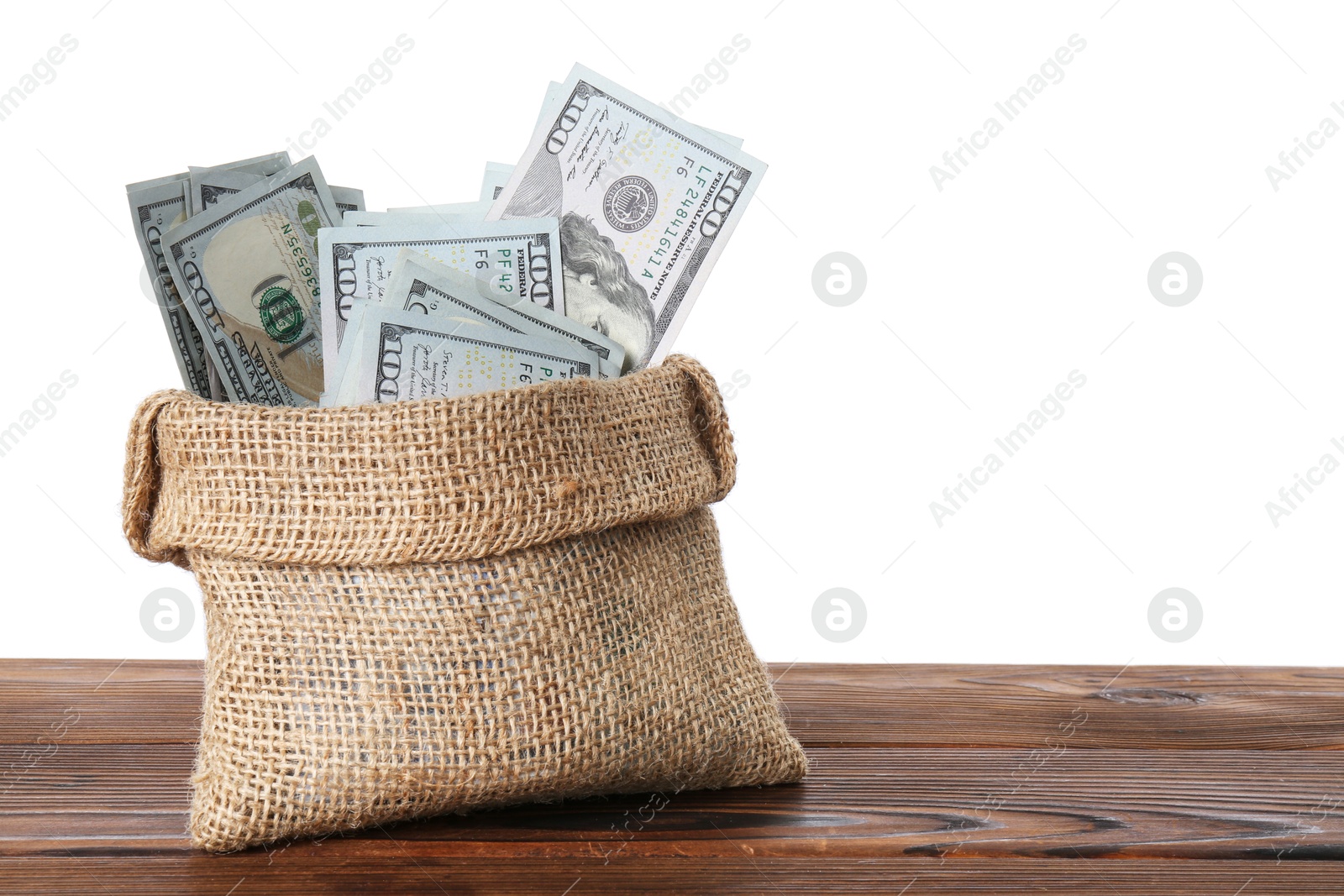 Photo of Dollar banknotes in bag on wooden table against white background, space for text