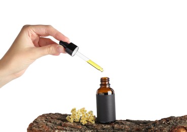 Woman dripping tincture from pipette into bottle against white background, closeup