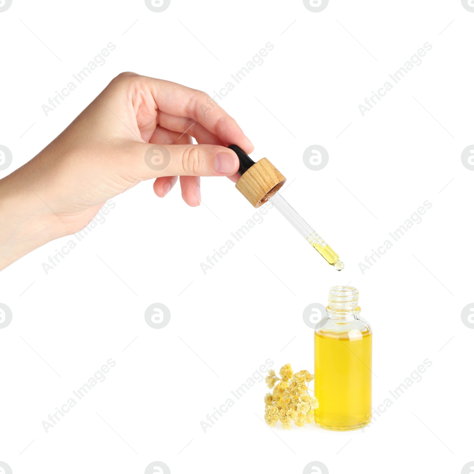 Photo of Woman dripping tincture from pipette into bottle on white background, closeup