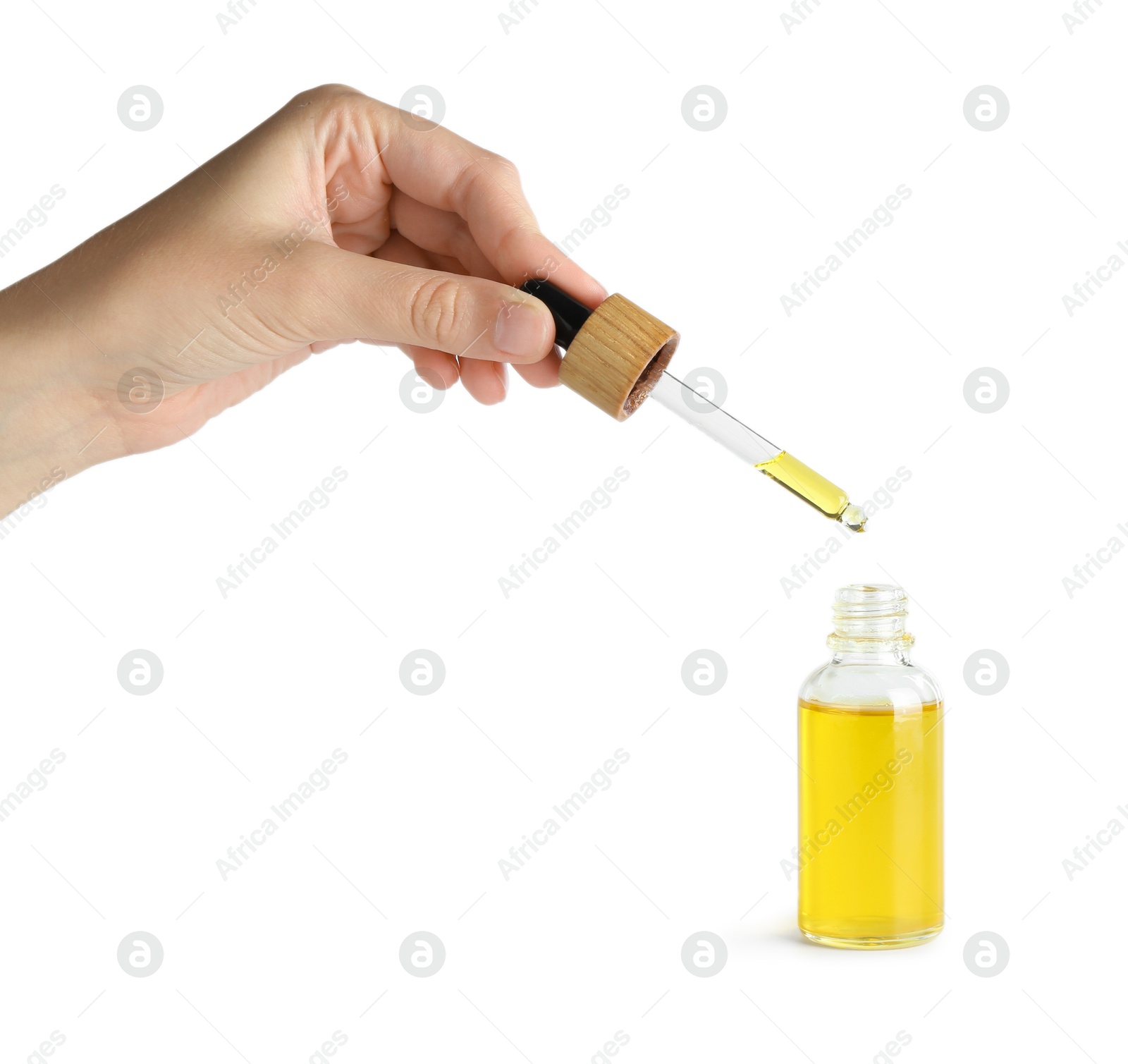 Photo of Woman dripping tincture from pipette into bottle on white background, closeup