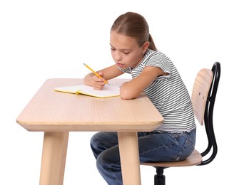 Photo of Girl with incorrect posture and notebook sitting at wooden desk on white background