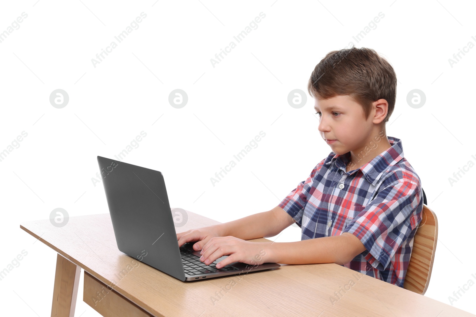 Photo of Boy with correct posture using laptop at wooden desk on white background