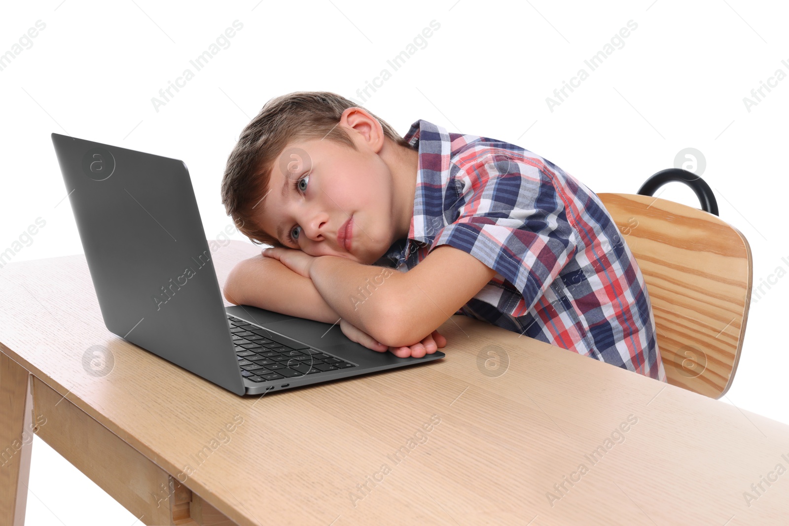 Photo of Boy with incorrect posture using laptop at wooden desk on white background