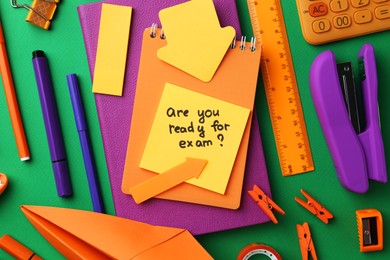 Paper note with question Are You Ready For Exam and stationery on green background, flat lay