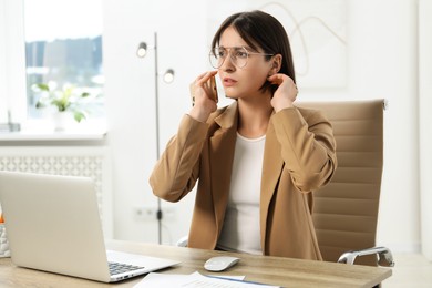 Photo of Beautiful woman with smartphone listening to voice message in office