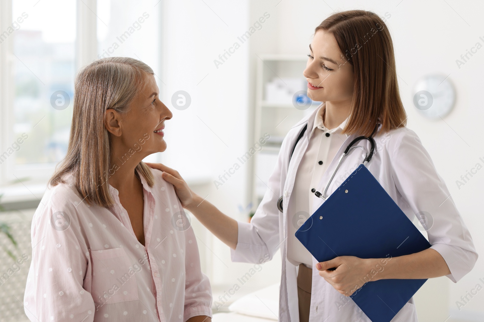 Photo of Smiling healthcare worker supporting senior patient in hospital