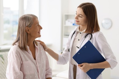 Photo of Smiling healthcare worker supporting senior patient in hospital