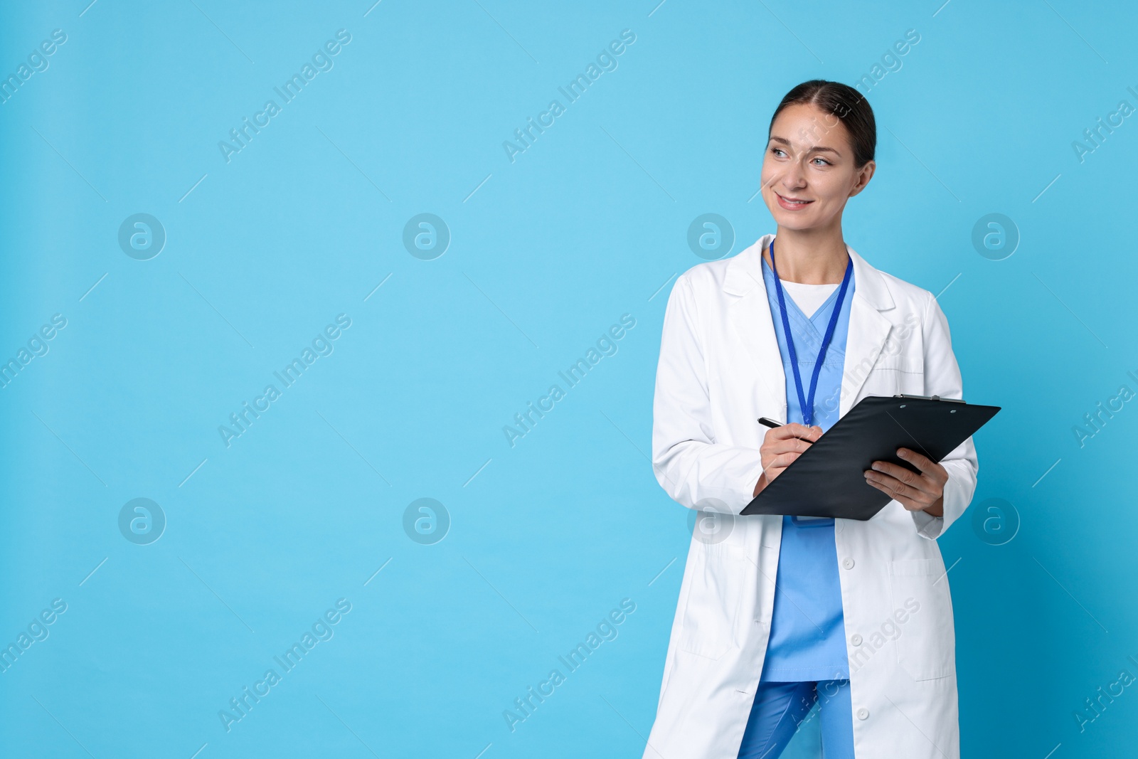 Photo of Nurse in medical uniform with clipboard on light blue background, space for text