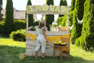 Little girl near lemonade stand in park