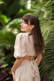 Photo of Beautiful woman posing in tropical forest, back view