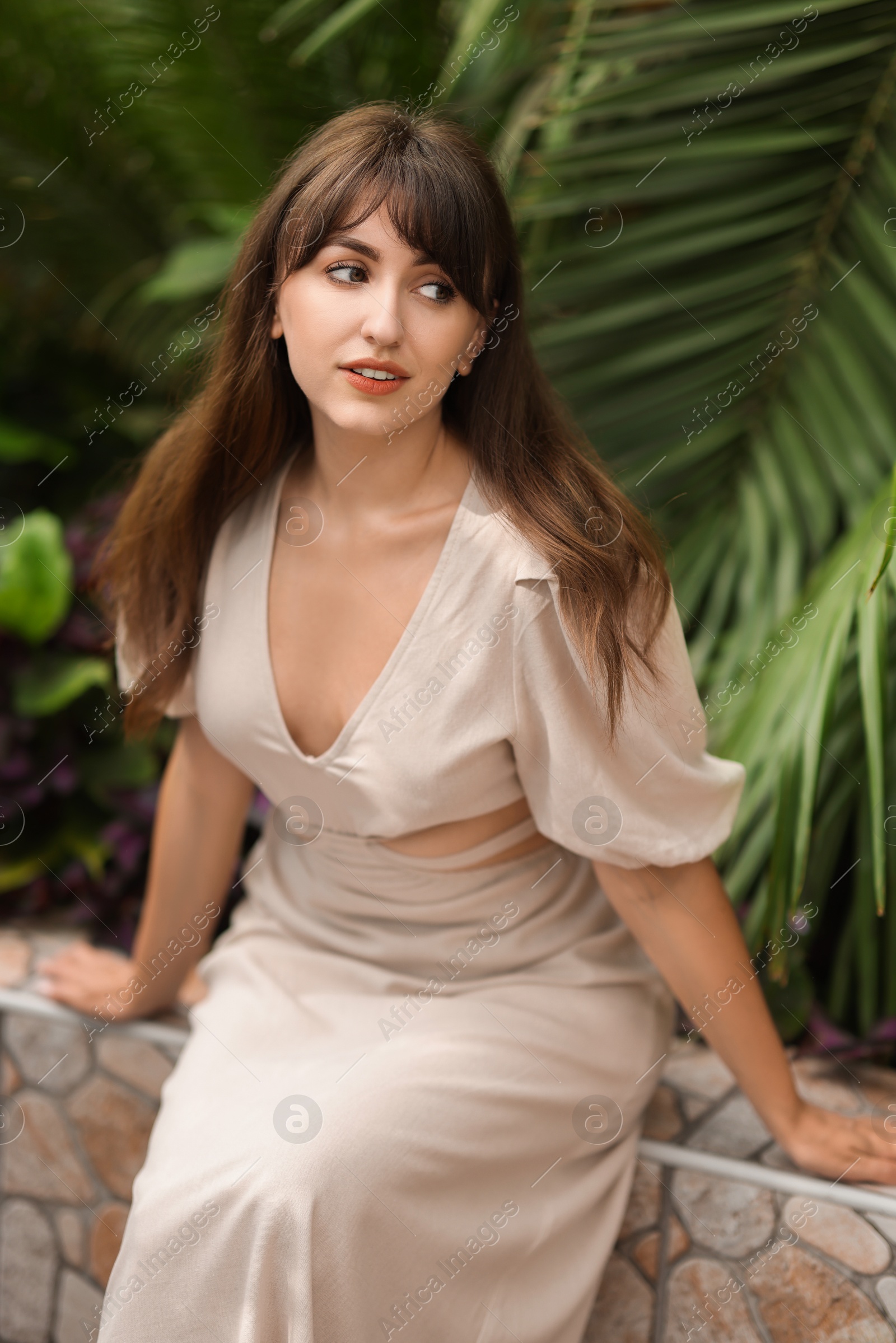 Photo of Beautiful woman posing near palm plants outdoors