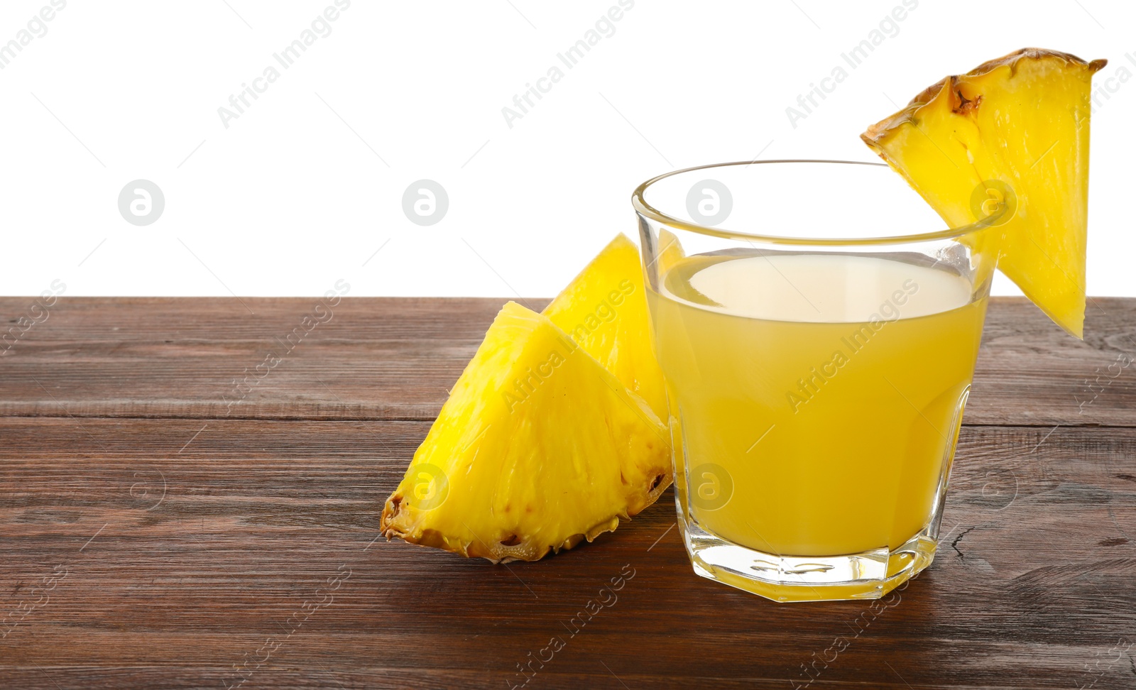 Photo of Glass with pineapple juice and pieces of fresh fruit on wooden table against white background