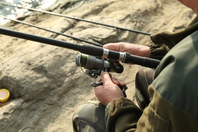 Fisherman with rod fishing near lake at summer, closeup