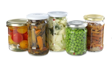 Photo of Different pickled products in jars isolated on white