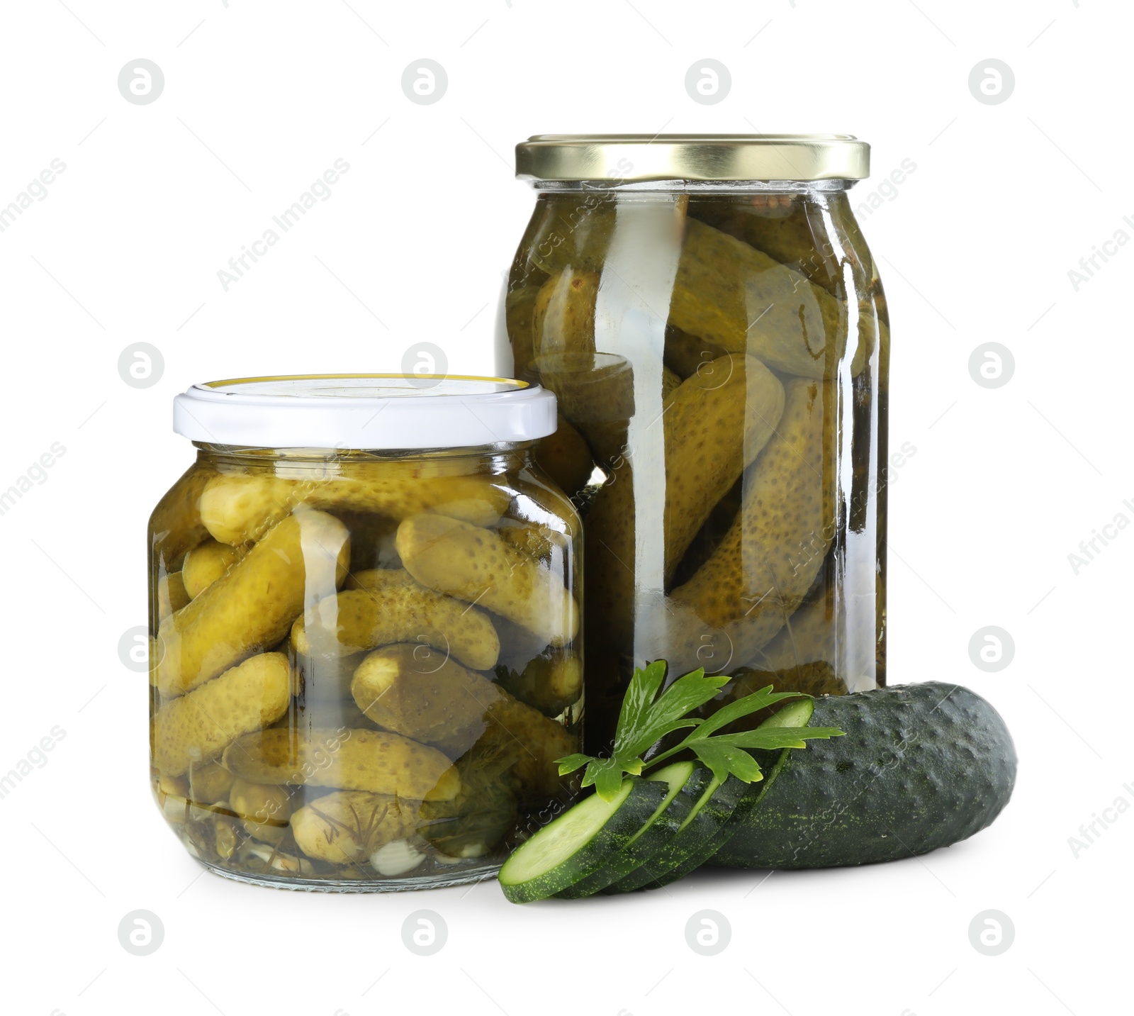 Photo of Tasty pickled cucumbers in jars, fresh vegetable and parsley isolated on white