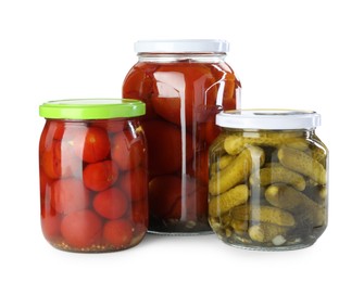 Photo of Tasty pickled tomatoes and cucumbers in jars isolated on white