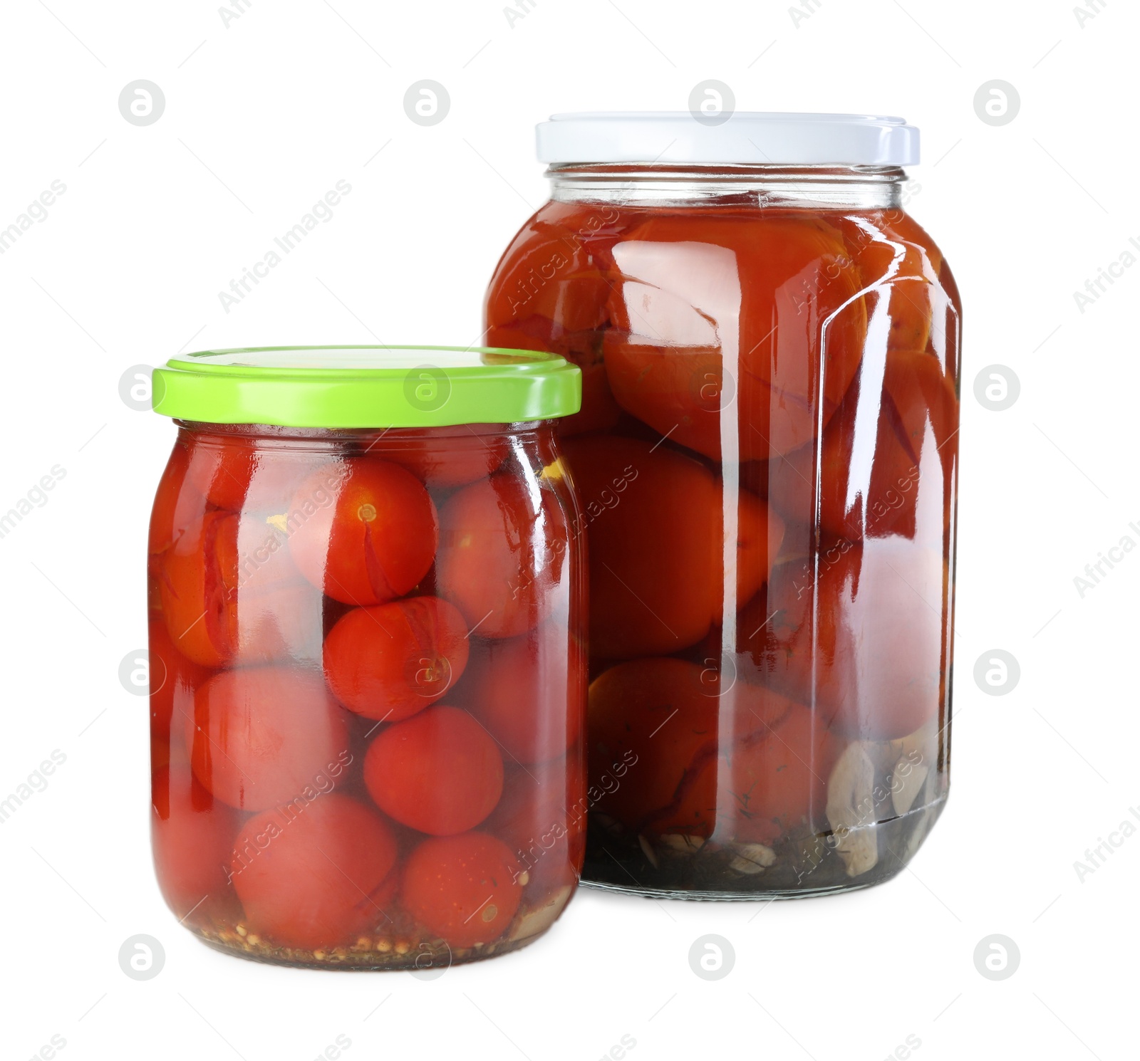 Photo of Tasty pickled tomatoes in jars isolated on white