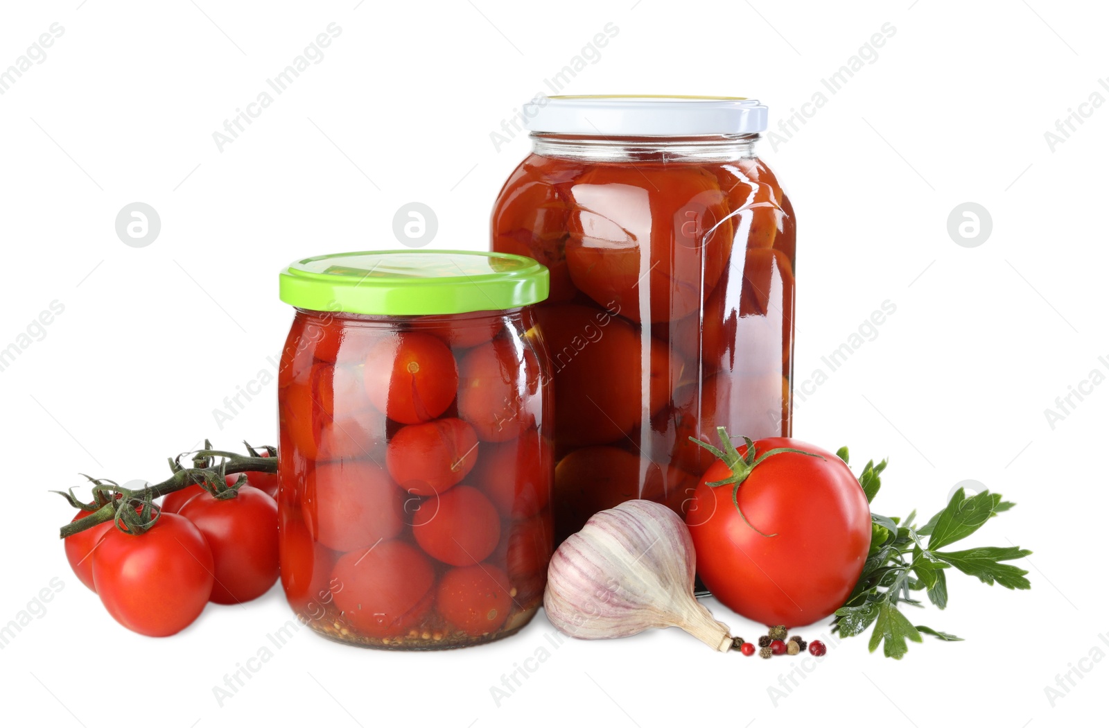 Photo of Tasty pickled tomatoes in jars, fresh vegetables and spices isolated on white