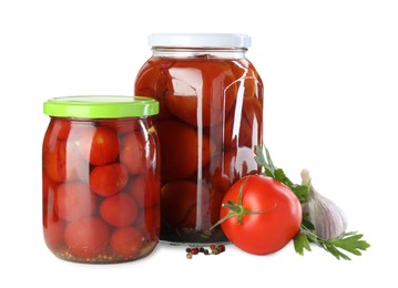 Photo of Tasty pickled tomatoes in jars, fresh vegetable and spices isolated on white