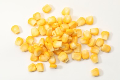 Photo of Pile of fresh corn kernels on white background, flat lay