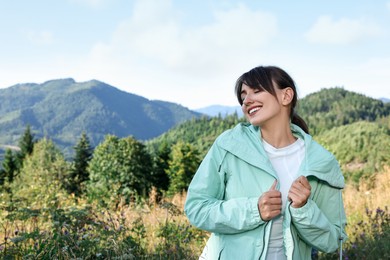 Photo of Smiling woman in beautiful mountains, space for text