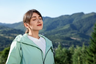 Photo of Young woman in beautiful mountains, space for text