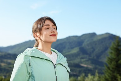 Young woman in beautiful mountains, space for text