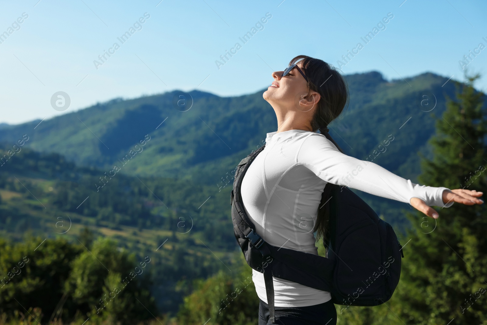 Photo of Young woman in sunglasses with backpack in beautiful mountains