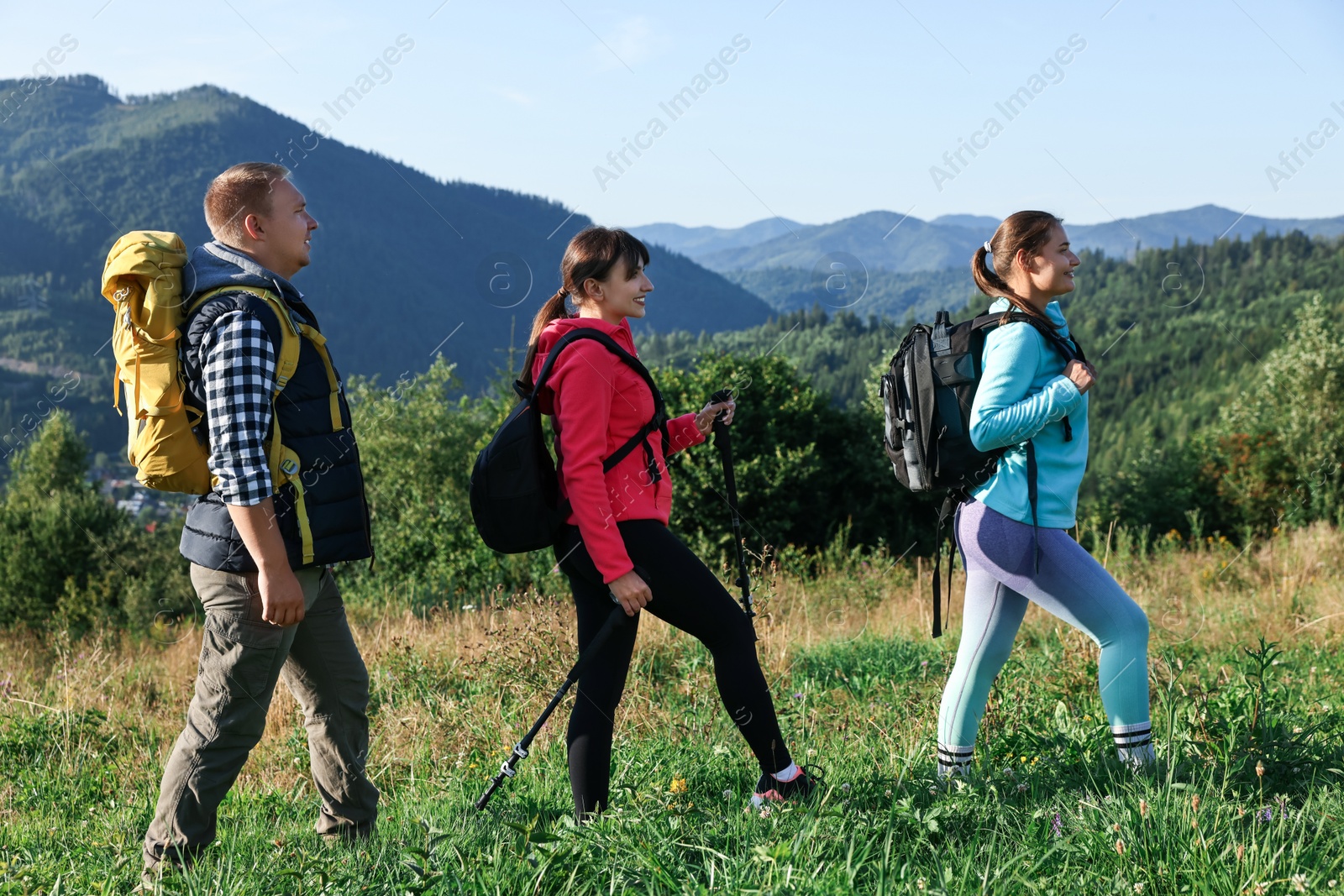 Photo of Friends with backpacks walking in beautiful mountains