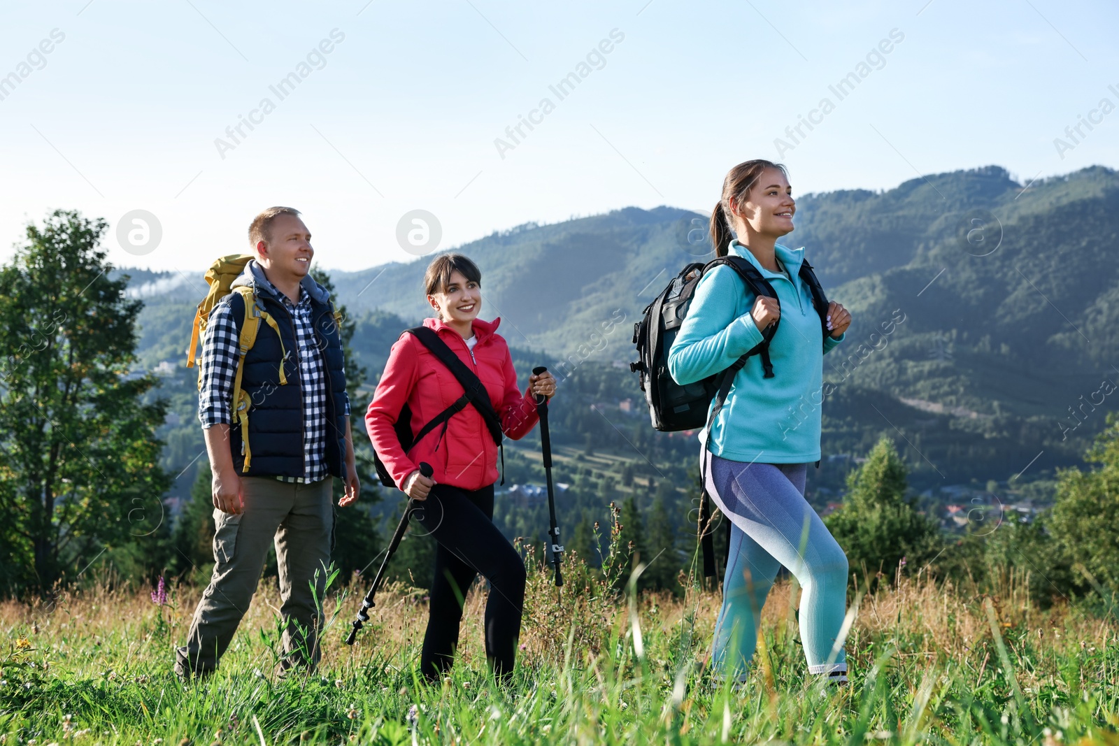 Photo of Friends with backpacks walking in beautiful mountains