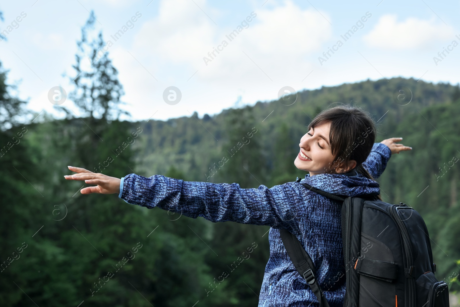 Photo of Smiling woman with backpack in beautiful mountains