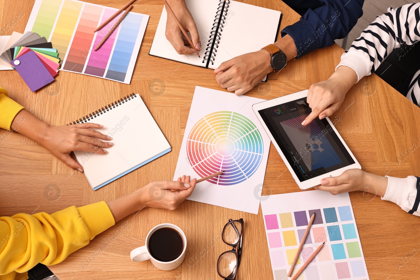 Photo of Group of designers working together at table, closeup