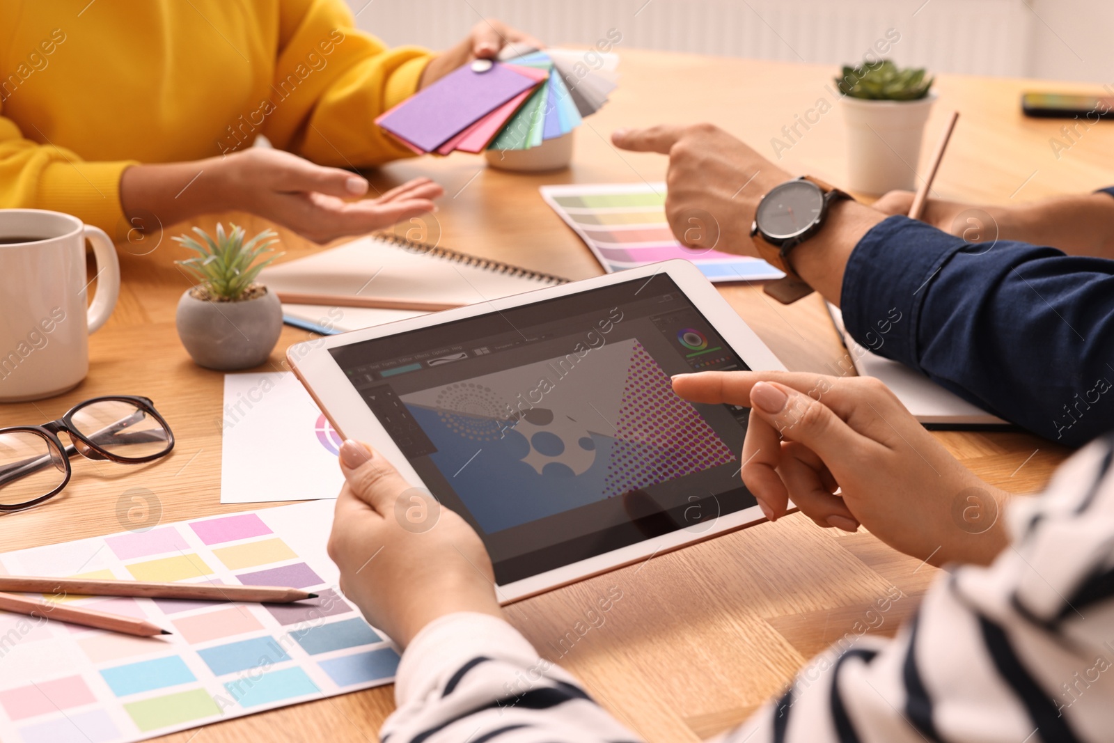 Photo of Group of designers working together at table, closeup