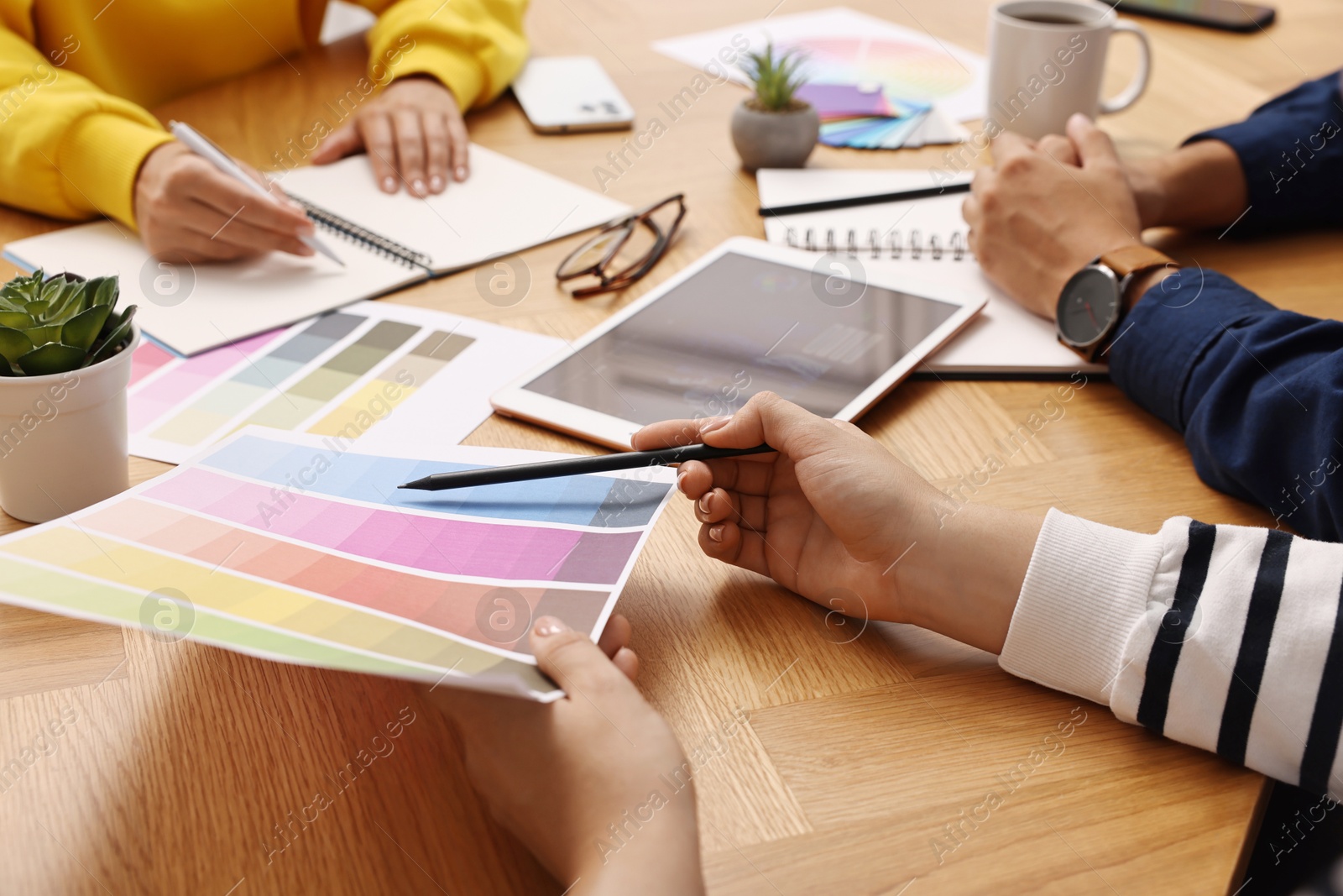 Photo of Group of designers working together at table, closeup