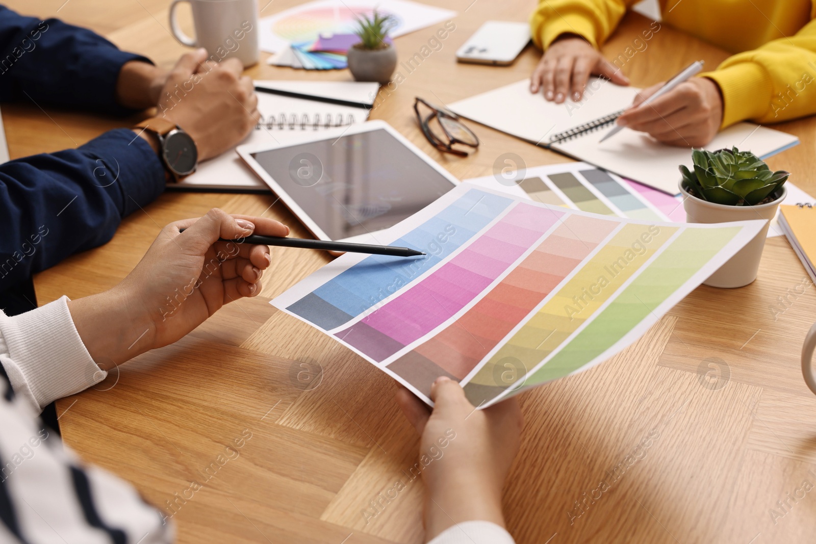 Photo of Group of designers working together at table, closeup