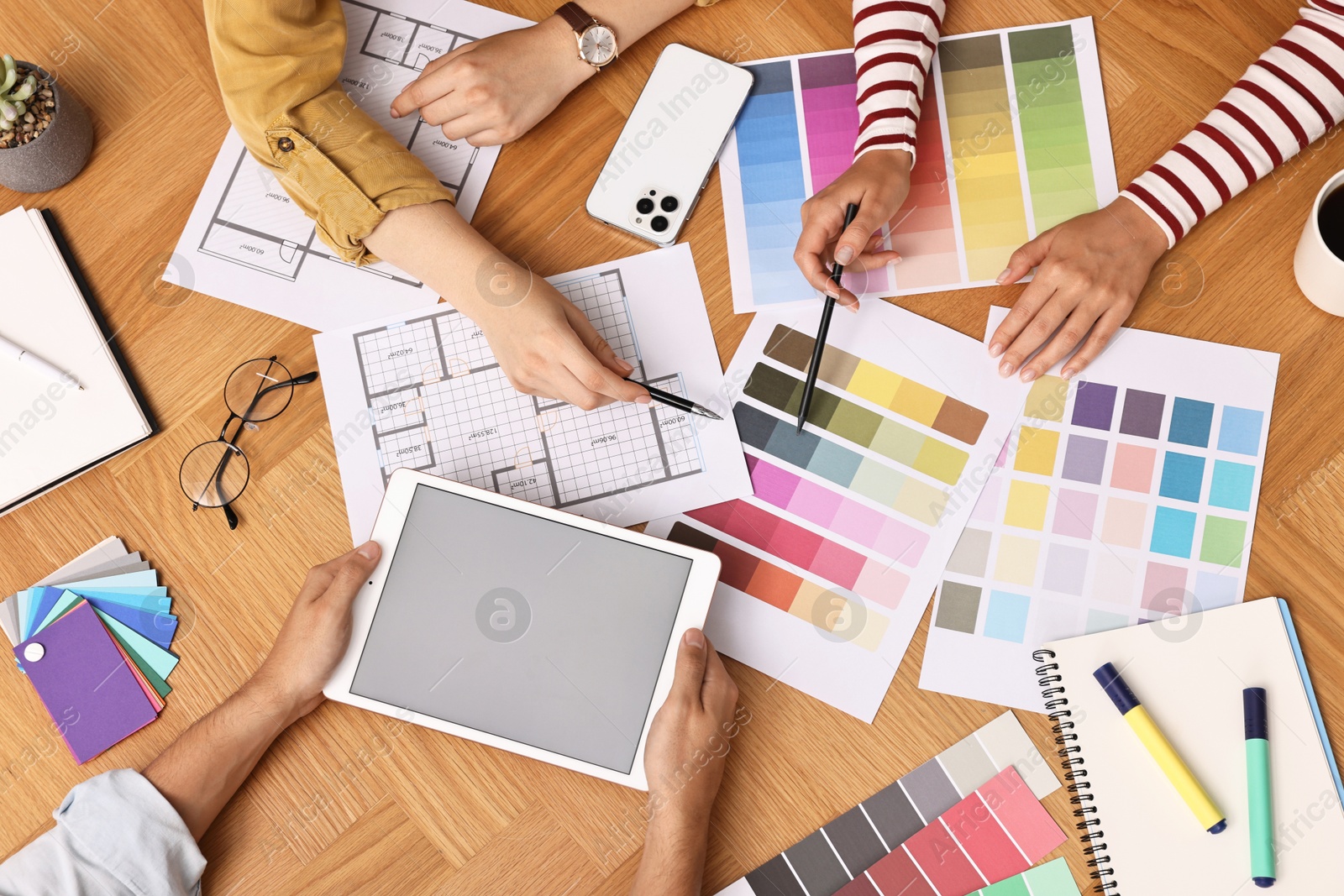 Photo of Group of designers working together at table, closeup