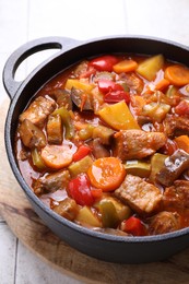 Photo of Delicious stew with vegetables in pot on table, closeup