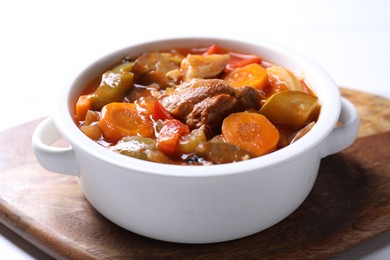 Photo of Delicious stew with vegetables in bowl on white table, closeup