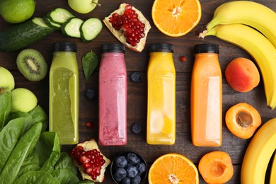 Glass bottles of tasty smoothies and different products on wooden table, flat lay