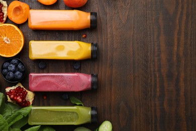 Glass bottles of tasty smoothies and different products on wooden table, flat lay. Space for text