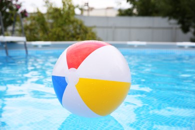 Inflatable ball floating on water in above ground swimming pool outdoors