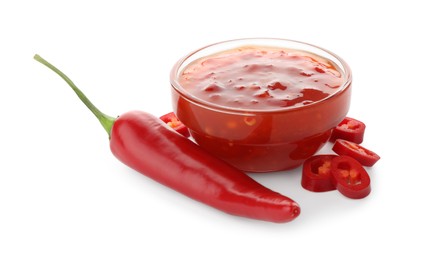 Photo of Hot chili sauce in bowl and pepper isolated on white