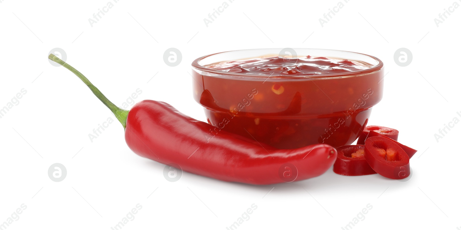 Photo of Hot chili sauce in bowl and pepper isolated on white