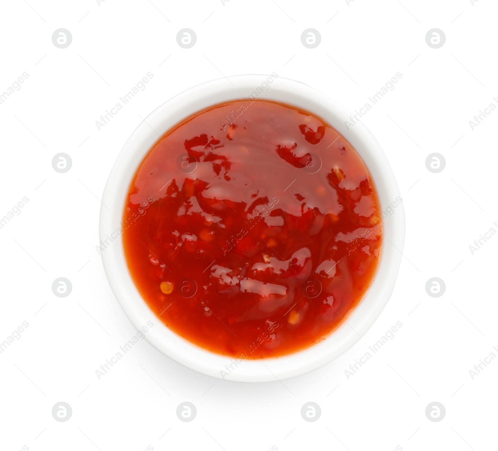 Photo of Hot chili sauce in bowl isolated on white, top view