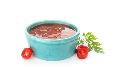 Photo of Hot chili sauce in bowl, parsley and cut pepper isolated on white