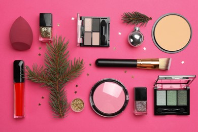 Photo of Flat lay composition with makeup products and Christmas decor on pink background