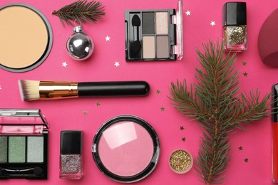 Photo of Flat lay composition with makeup products and Christmas decor on pink background